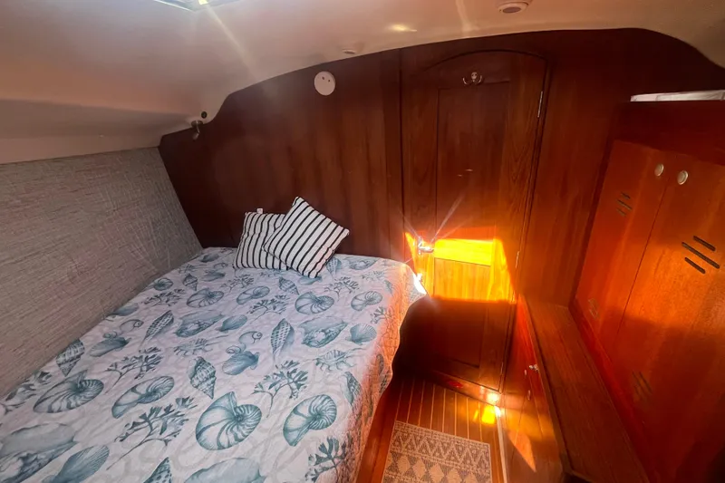 Slide: The Image of Cozy cabin interior of 2002 Hunter 410 sailboat with nautical-themed bedding. - 13