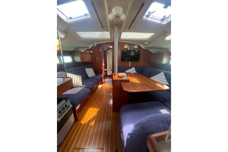 Slide: The Image of Interior of 2002 Hunter 410 sailboat with cozy seating and wooden finishes. - 2