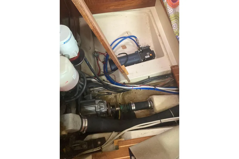 Slide: The Image of Engine compartment of a 2002 Hunter 410 sailboat, showing mechanical components and wiring. - 23