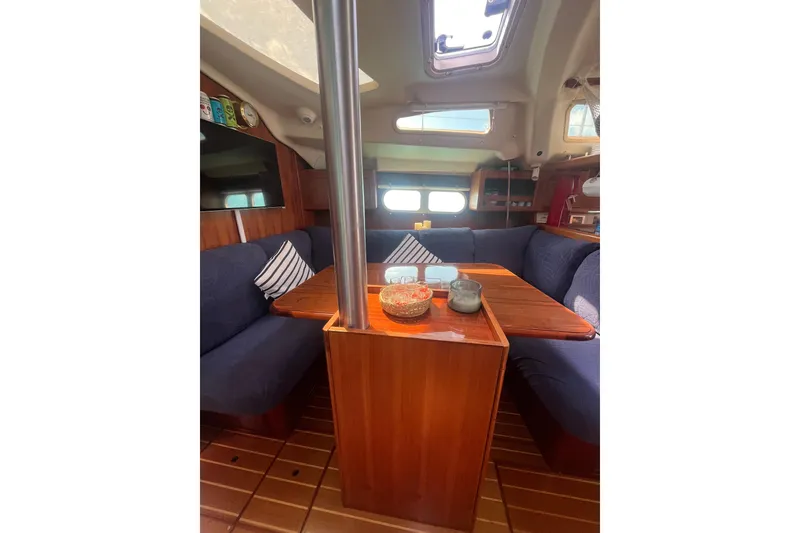 Slide: The Image of Interior of a 2002 Hunter 410 sailboat with cozy seating and wooden table. - 3