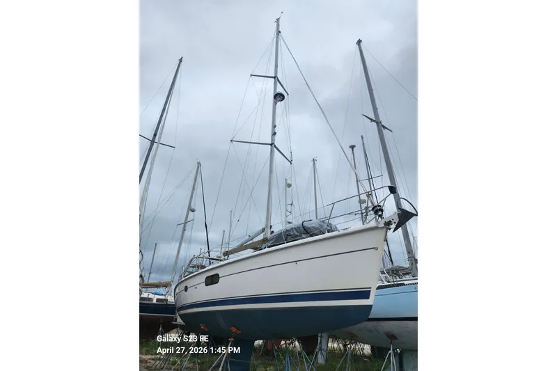 Slide: The Image of 2002 Hunter 410 sailboat on stands, cloudy sky background. - 38