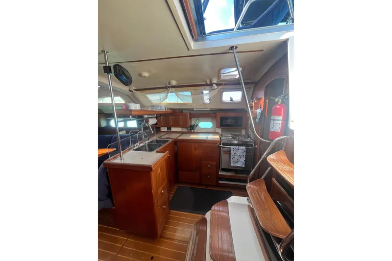 Slide: The Image of Interior of 2002 Hunter 410 sailboat with wooden cabinetry and modern kitchen amenities. - 7
