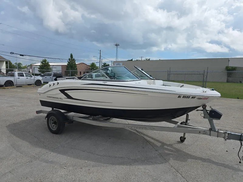 The Image of 2016 Chaparral 18 H2O Sport boat on trailer, parked outdoors under cloudy sky. - 0
