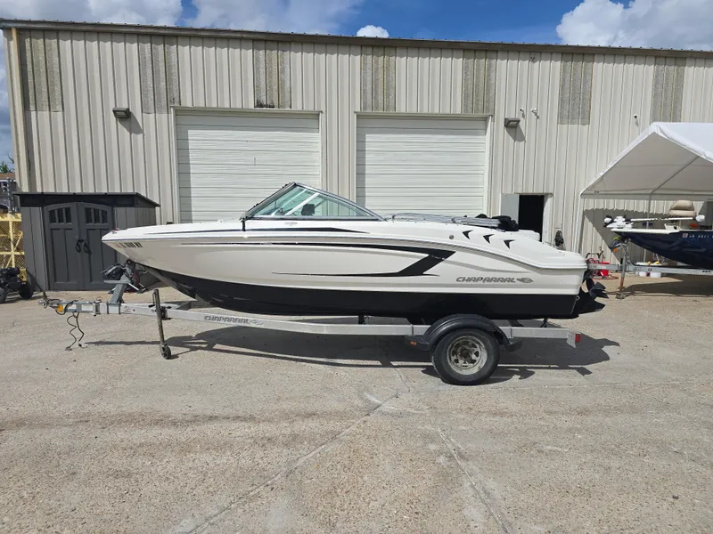 Slide: The Image of 2016 Chaparral 18 H2O Sport boat on trailer, parked outside a warehouse. - 2