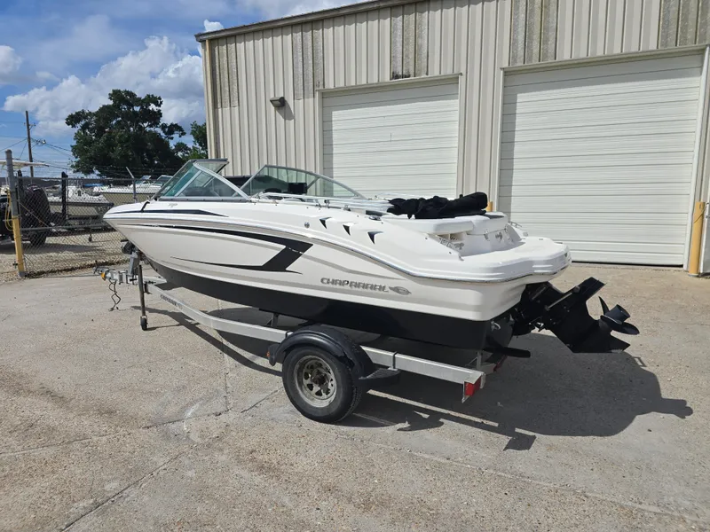 Slide: The Image of 2016 Chaparral 18 H2O Sport boat on trailer, parked outside a garage. - 3