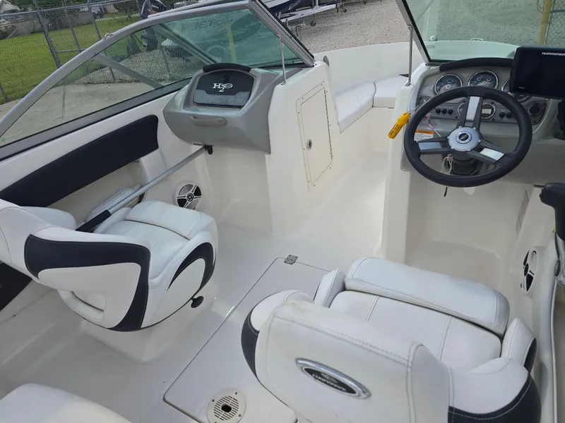 Slide: The Image of 2016 Chaparral 18 H2O Sport boat interior with white seating and steering console. - 8