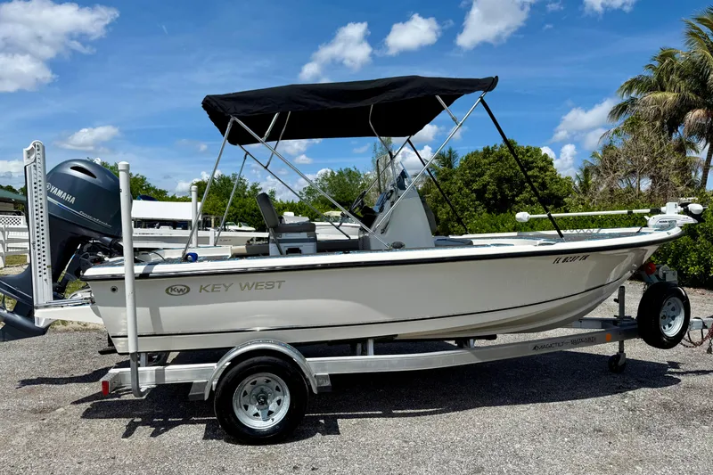 The Image of 2023 Key West 188 Bay Reef boat on trailer, featuring Yamaha engine, under blue sky. - 0