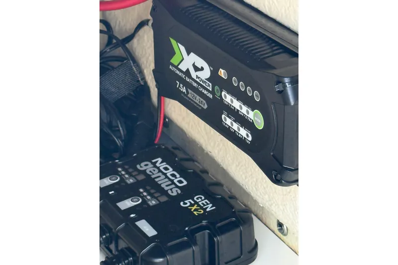 Slide: The Image of Battery chargers in a 2023 Key West 188 Bay Reef boat, featuring NOCO Genius and XS Power models. - 23