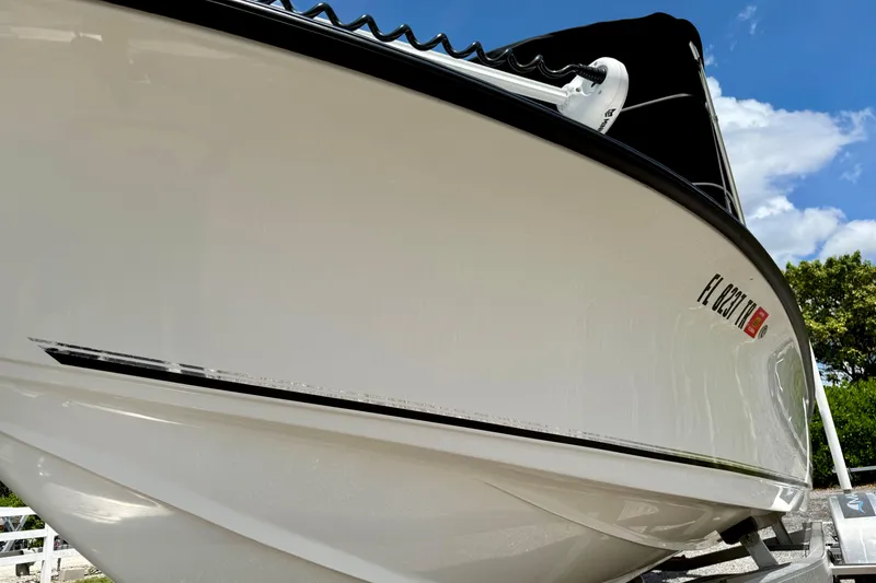 Slide: The Image of 2023 Key West 188 Bay Reef boat, sleek white hull, under clear blue sky. - 4