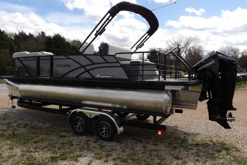 Slide: The Image of 2026 Sylvan X3 CLZ DH pontoon boat on trailer, featuring Mercury outboard motor. - 13