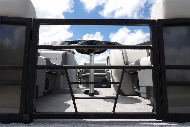 Slide: The Image of 2026 Sylvan X3 CLZ DH pontoon boat interior with seating, viewed through open gate. - 42