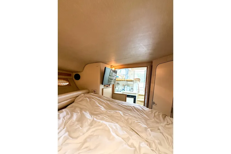 Slide: The Image of Interior cabin view of a 1995 Sea Ray 370 Sedan Bridge yacht with cozy bedding. - 27