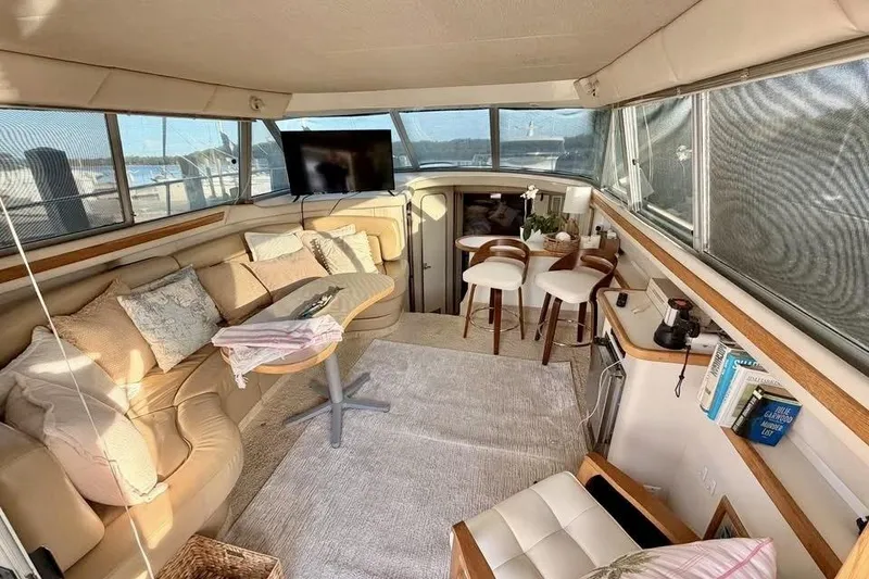 Slide: The Image of Interior of 1995 Sea Ray 370 Sedan Bridge with compact fridge and wooden accents. - 11