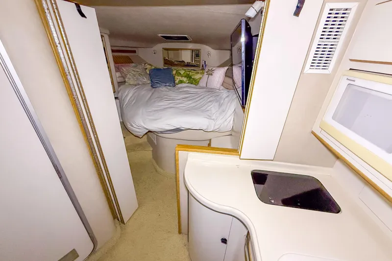 Slide: The Image of Interior cabin of 1995 Sea Ray 370 Sedan Bridge with cozy bed and kitchenette. - 16