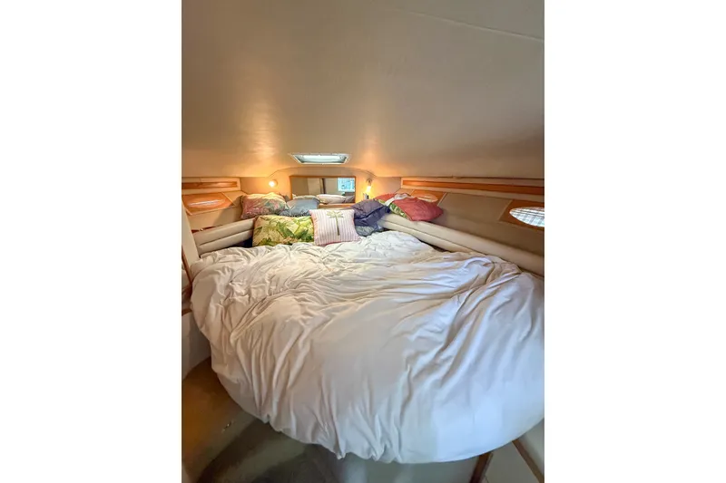 Slide: The Image of Cozy cabin interior of 1995 Sea Ray 370 Sedan Bridge with plush bedding and pillows. - 26