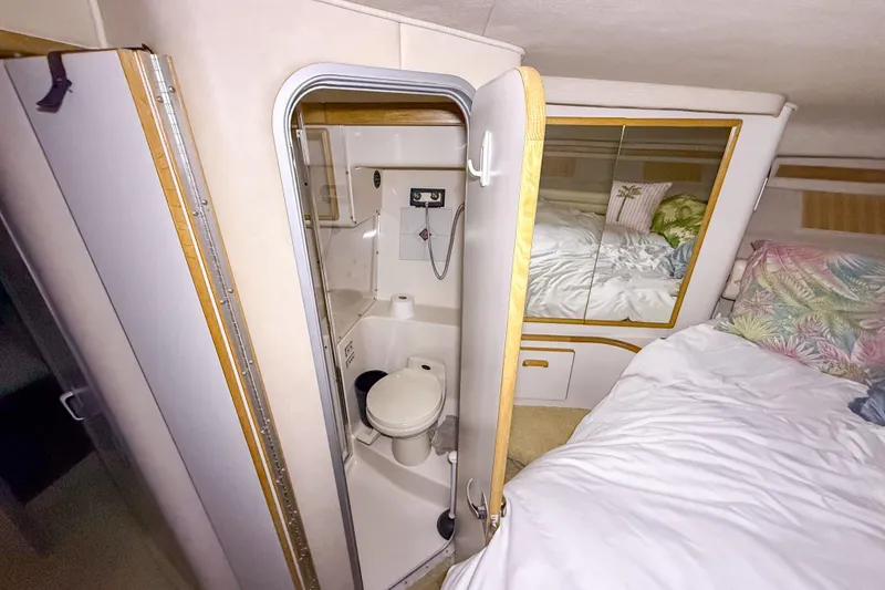 Slide: The Image of 1995 Sea Ray 370 Sedan Bridge interior with compact bathroom and cozy bedroom. - 20