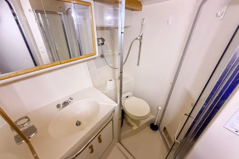 Slide: The Image of Bathroom interior of 1995 Sea Ray 370 Sedan Bridge yacht, featuring sink, toilet, and shower. - 21