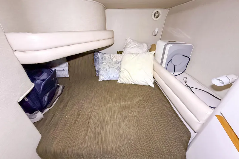 Slide: The Image of Cozy cabin interior of 1995 Sea Ray 370 Sedan Bridge with pillows and storage. - 25
