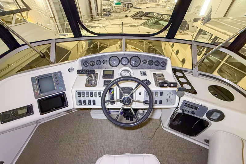 Slide: The Image of Cockpit of 1995 Sea Ray 370 Sedan Bridge with steering wheel and navigation instruments. - 28