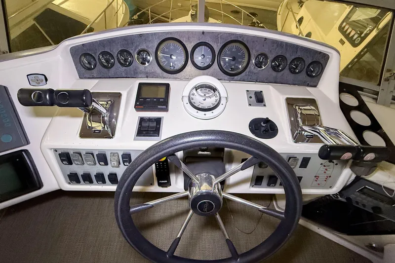 Slide: The Image of 1995 Sea Ray 370 Sedan Bridge helm with gauges, steering wheel, and controls. - 29