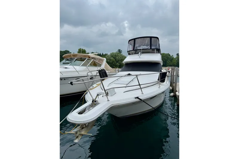 Slide: The Image of 1995 Sea Ray 370 Sedan Bridge yacht docked at marina under cloudy skies. - 4