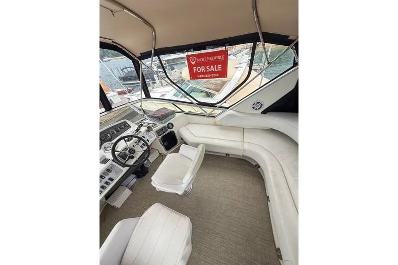Slide: The Image of 1995 Sea Ray 370 Sedan Bridge interior with "For Sale" sign, featuring helm and seating area. - 33