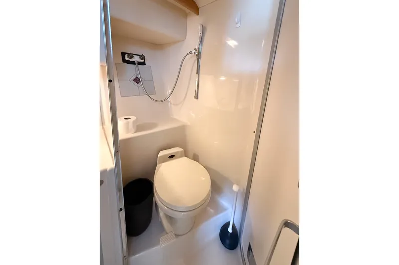 Slide: The Image of Compact bathroom in a 1995 Sea Ray 370 Sedan Bridge yacht, featuring a toilet and shower. - 24