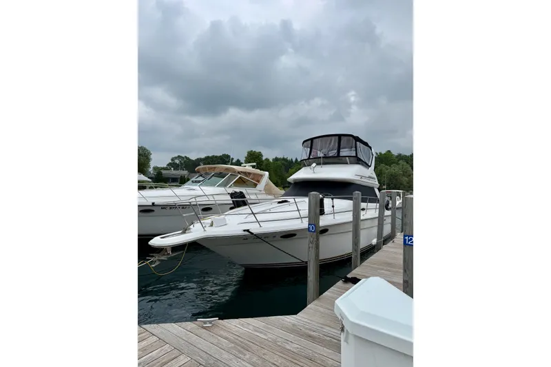 Slide: The Image of 1995 Sea Ray 370 Sedan Bridge yacht docked at marina under cloudy skies. - 5
