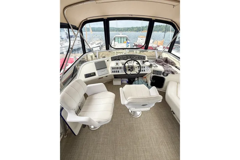 Slide: The Image of 1995 Sea Ray 370 Sedan Bridge helm with white seating and lake view. - 28