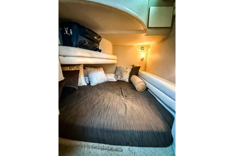 Slide: The Image of Cozy cabin interior of 1995 Sea Ray 370 Sedan Bridge with plush bedding and ambient lighting. - 21
