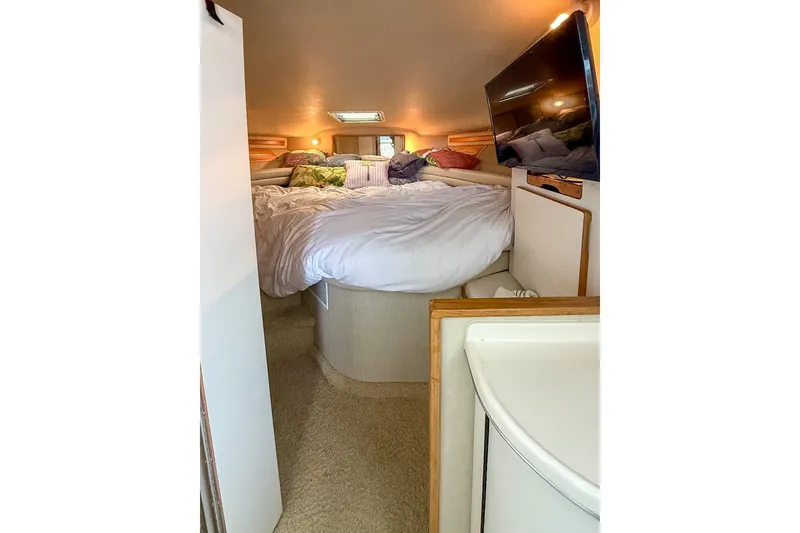 Slide: The Image of Cozy bedroom interior of 1995 Sea Ray 370 Sedan Bridge yacht with TV and bedding. - 25