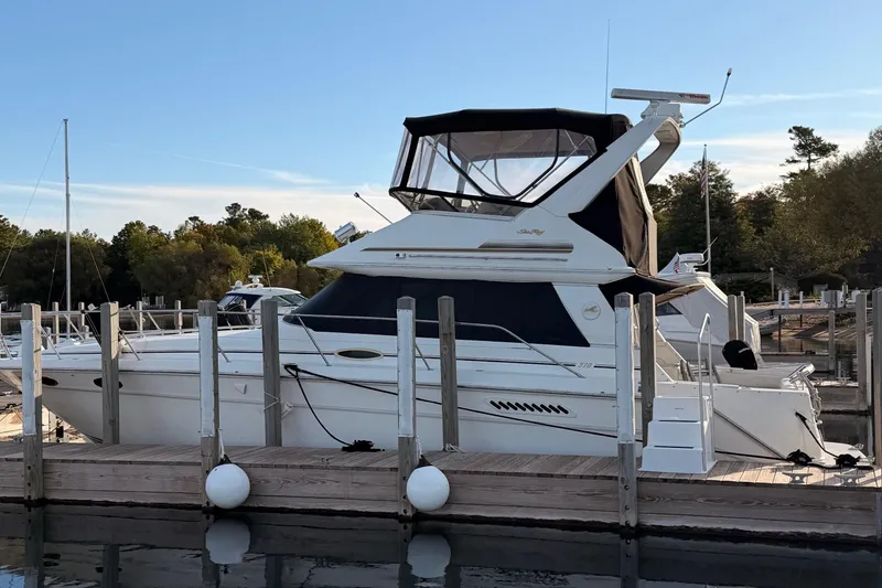 The Image of 1996 Sea Ray 370 Sedan Bridge yacht docked at marina, side view. - 1