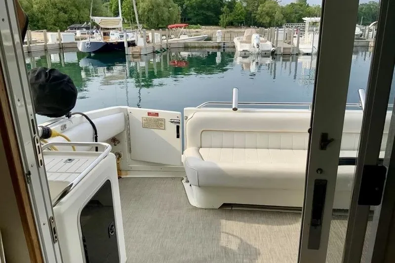 Slide: The Image of 1996 Sea Ray 370 Sedan Bridge yacht interior with white seating, docked at marina. - 12
