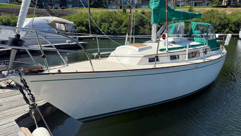 The Image of 1981 Sabre 28 sailboat docked, featuring green sail covers and sleek white hull. - 0