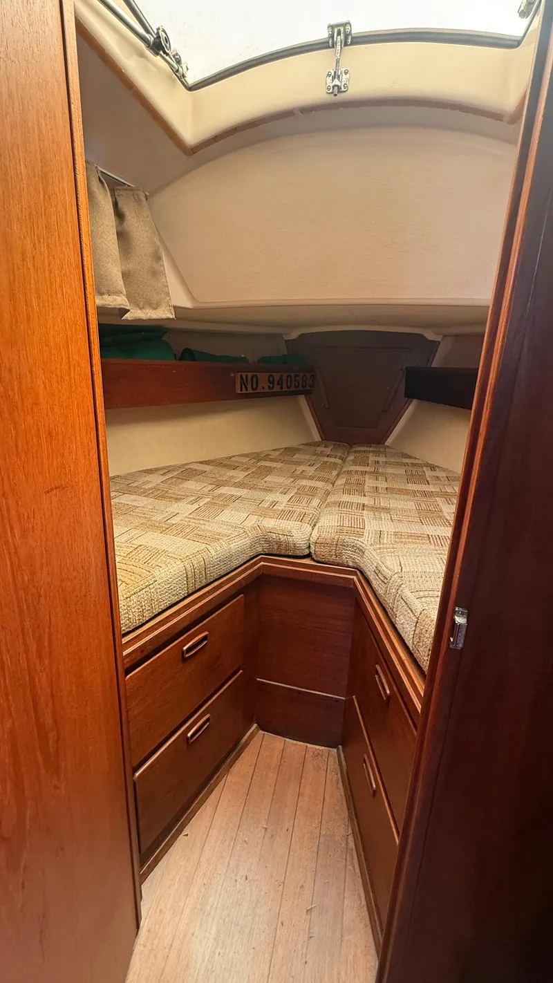 Slide: The Image of 1981 Sabre 28 sailboat interior with cozy V-berth and wooden cabinetry. - 12