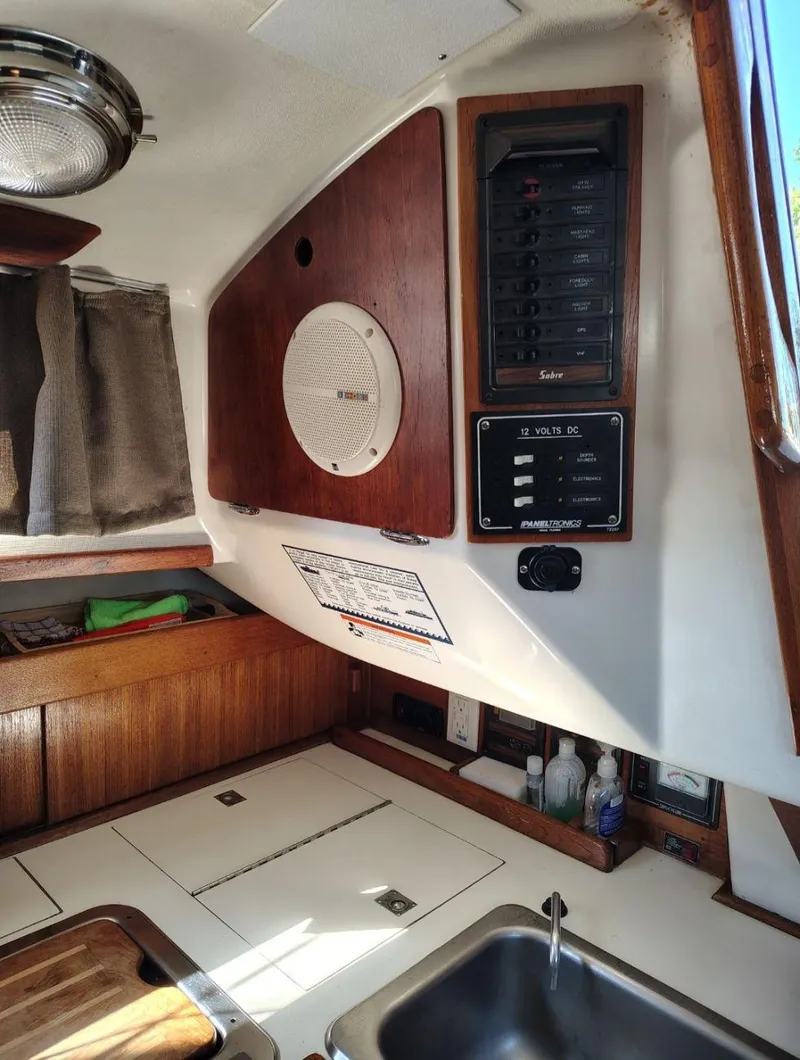 Slide: The Image of 1981 Sabre 28 sailboat interior with control panel, speaker, and sink area. - 14