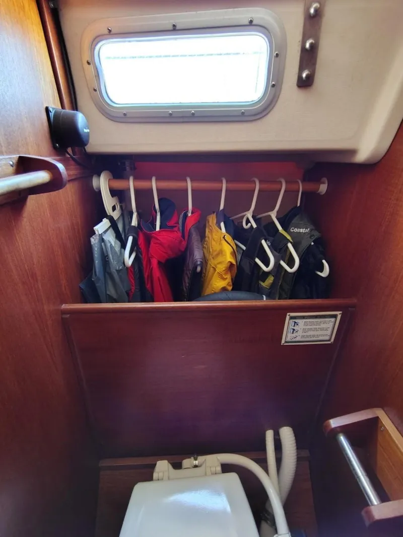 Slide: The Image of Interior of 1981 Sabre 28 sailboat with hanging jackets and marine toilet. - 16