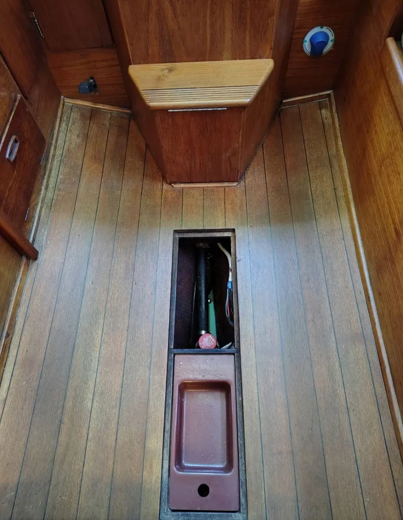 Slide: The Image of 1981 Sabre 28 sailboat interior with wooden flooring and open compartment. - 18