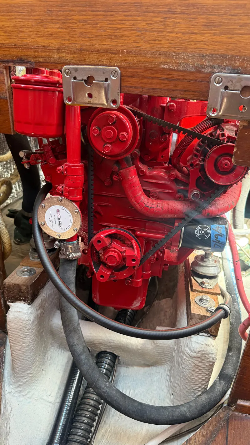 Slide: The Image of Red engine of a 1981 Sabre 28 sailboat, featuring belts and hoses. - 24