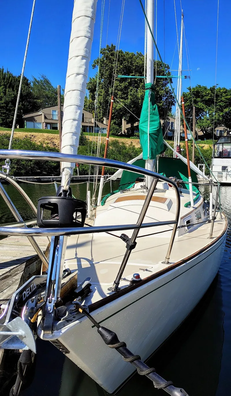 Slide: The Image of 1981 Sabre 28 sailboat docked, featuring white hull and green sail cover. - 26