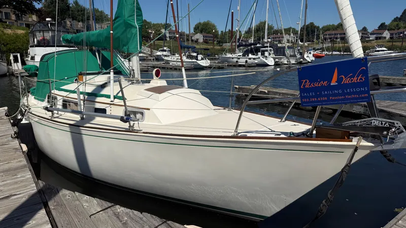 Slide: The Image of 1981 Sabre 28 sailboat docked, featuring green sail cover, with Passion Yachts sign. - 33