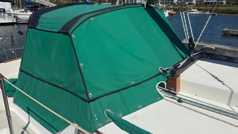 Slide: The Image of 1981 Sabre 28 sailboat with green canvas cover docked at marina. - 37