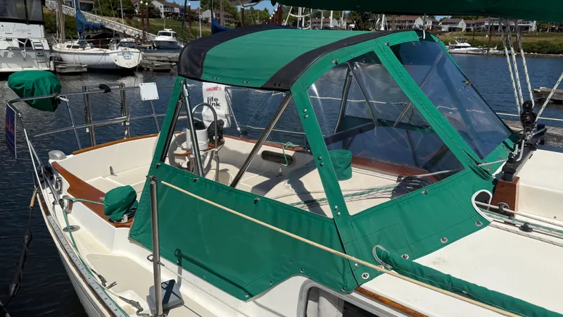 Slide: The Image of 1981 Sabre 28 sailboat with green canopy docked at marina. - 38