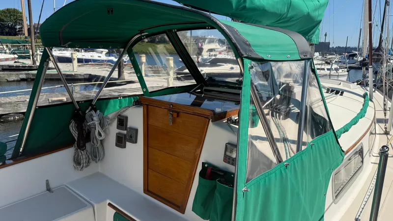 Slide: The Image of 1981 Sabre 28 sailboat cockpit with green canopy, docked at marina. - 41