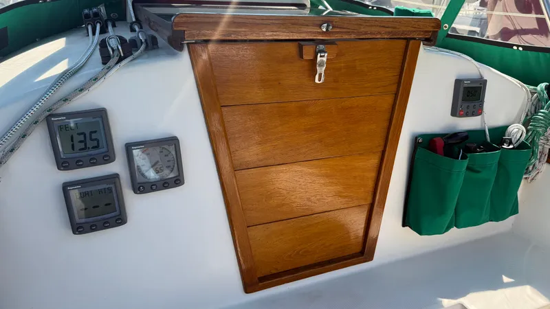 Slide: The Image of 1981 Sabre 28 sailboat cockpit with wooden hatch, digital instruments, and green storage pockets. - 46