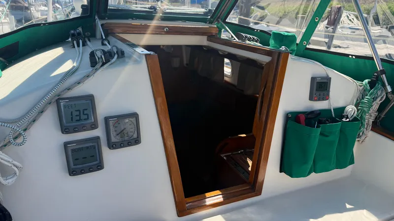 Slide: The Image of 1981 Sabre 28 sailboat cockpit with navigation instruments and green storage pockets. - 48