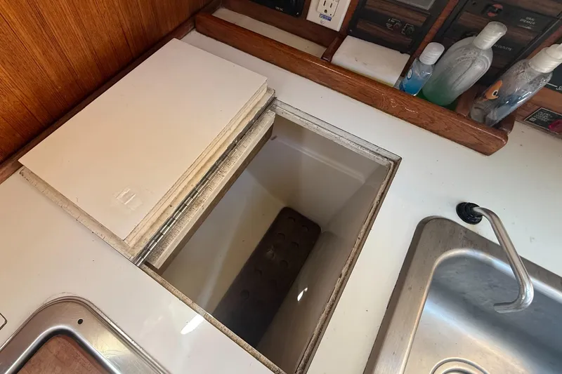 Slide: The Image of Interior of a 1981 Sabre 28 sailboat showing a galley sink and storage compartment. - 9
