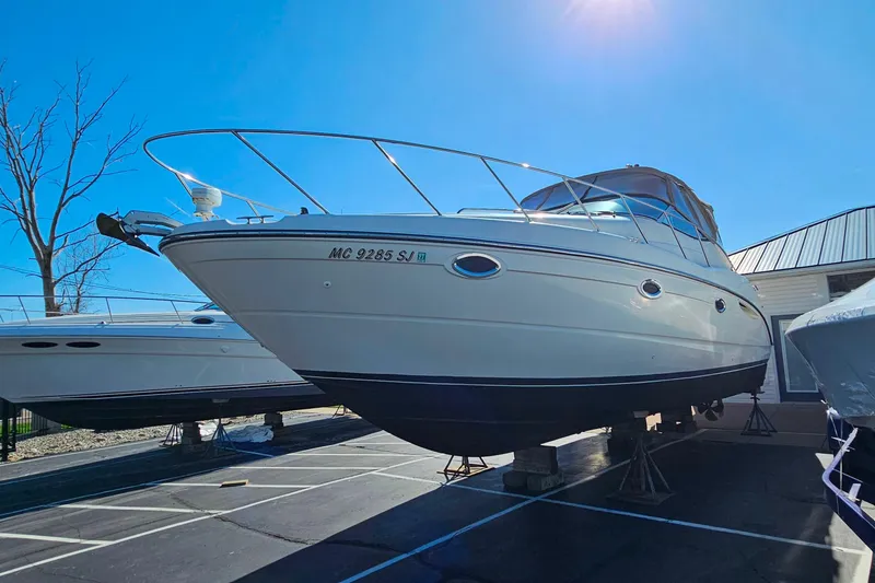 The Image of 2001 Maxum 3500 SCR boat on dry dock under clear blue sky. - 0