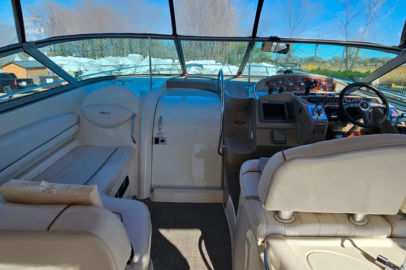 Slide: The Image of 2001 Maxum 3500 SCR boat interior with helm, seating, and dashboard under clear blue sky. - 13