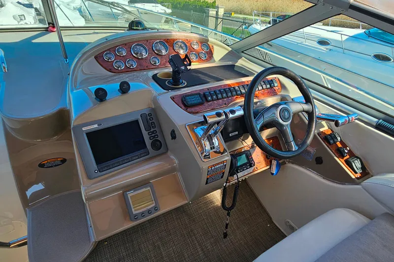 Slide: The Image of 2001 Maxum 3500 SCR boat cockpit with steering wheel, control panel, and navigation instruments. - 14
